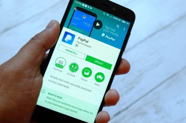 Bandar Seri Begawan, Brunei - 25 Temmuz 2018: Paypal apps ile akıllı telefon android Google oyun satan bir yerde tutan bir erkek el