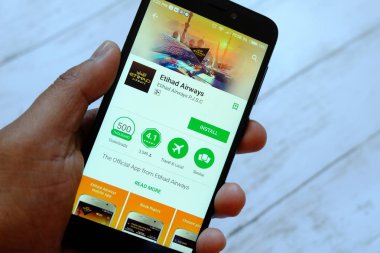 Bandar Seri Begawan, Brunei - 25 Temmuz 2018: Etihad Havayolları app ile akıllı telefon android Google oyun satan bir yerde tutan bir erkek el