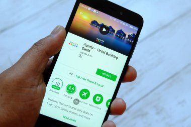 Bandar Seri Begawan, Brunei - 25 Temmuz 2018: Agoda app ile akıllı telefon android Google oyun satan bir yerde tutan bir erkek el