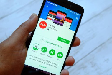 Bandar Seri Begawan, Brunei - 25 Temmuz 2018: smartphone ile arası Airasia app android Google oyun satan bir yerde tutan bir erkek el