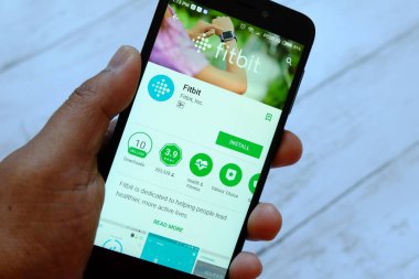 Bandar Seri Begawan, Brunei - 25 Temmuz 2018: Fitbit apps ile akıllı telefon android Google oyun satan bir yerde tutan bir erkek el
