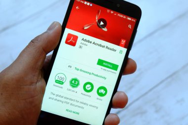 Bandar Seri Begawan, Brunei - 25 Temmuz 2018: Adobe Acrobat Reader uygulaması ile smartphone android Google oyun satan bir yerde tutan bir erkek el