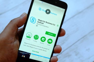 Bandar Seri Begawan, Brunei - 25 Temmuz 2018: Skype için iş uygulaması ile smartphone android Google oyun satan bir yerde tutan bir erkek el