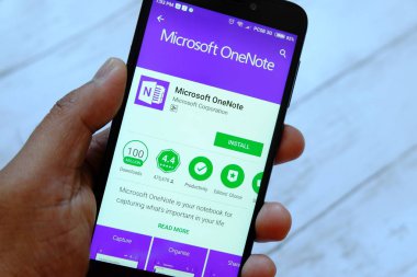 Bandar Seri Begawan, Brunei - 25 Temmuz 2018: Microsoft Onenote app ile akıllı telefon android Google oyun satan bir yerde tutan bir erkek el