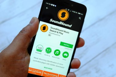 Bandar Seri Begawan, Brunei - 25 Temmuz 2018: Soundhound app ile akıllı telefon android Google oyun satan bir yerde tutan bir erkek el