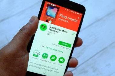 Bandar Seri Begawan, Brunei - 25 Temmuz 2018: smartphone ile Spotify app android Google oyun satan bir yerde tutan bir erkek el.