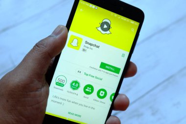 Bandar Seri Begawan, Brunei - 25 Temmuz 2018: Snapchat apps ile akıllı telefon android Google oyun satan bir yerde tutan bir erkek el