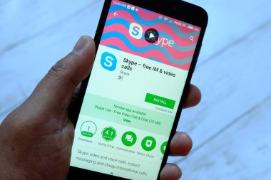 Bandar Seri Begawan, Brunei - 25 Temmuz 2018: Skype apps ile akıllı telefon android Google oyun satan bir yerde tutan bir erkek el