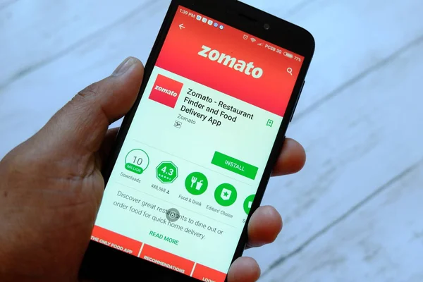 Bandar Seri Begawan, Brunei - 25 Temmuz 2018: Zomato uygulaması ile smartphone android Google oyun satan bir yerde tutan bir erkek el.