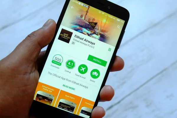 Bandar Seri Begawan, Brunei - 25 Temmuz 2018: Etihad Havayolları app ile akıllı telefon android Google oyun satan bir yerde tutan bir erkek el