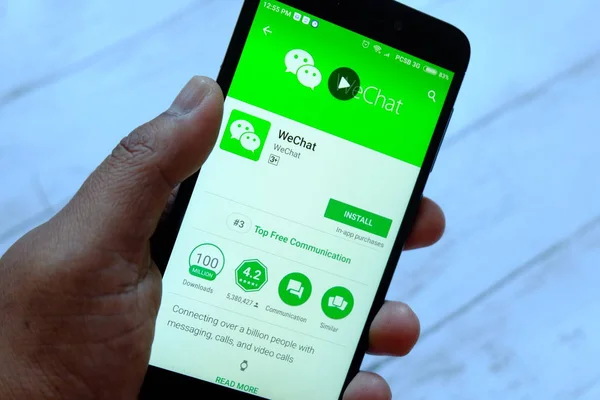 Bandar Seri Begawan, Brunei - 25 Temmuz 2018: Wechat apps ile akıllı telefon android Google oyun satan bir yerde tutan bir erkek el