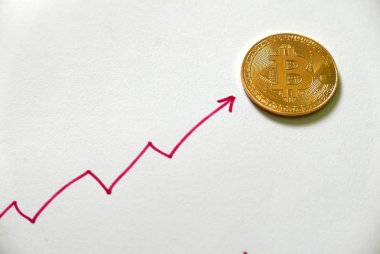 Altın bitcoin kopya beyaz ile kırmızı grafiği yukarı ve aşağı yazılı kağıt üzerinde. İş ve finans kavramı.