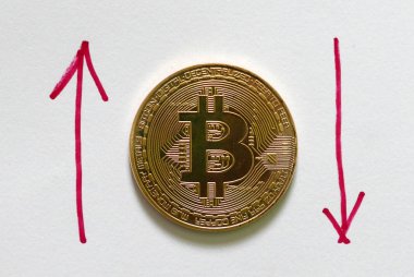 Altın bitcoin kopya beyaz ile kırmızı ok yukarı ve aşağı yazılı kağıt üzerinde. İş ve finans kavramı.
