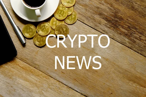 Bir fincan kahve, altın bitcoin yineleme, Not defteri ve kalem üstten görünüm kripto haber ile yazılı ahşap arka plan üzerinde.