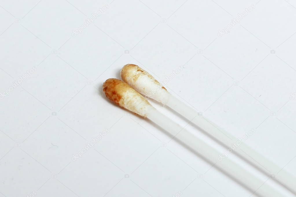 Ear wax on a cotton bud isolated on white background.