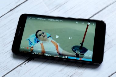 Kuala Lumpur, Malezya - 28 Ocak 2018: Yukarıdan Gangnam tarzı müzik video oynarken smartphone. Gangnam tarzıdır 18 K-pop single'ı Güney Koreli müzisyen Psy.