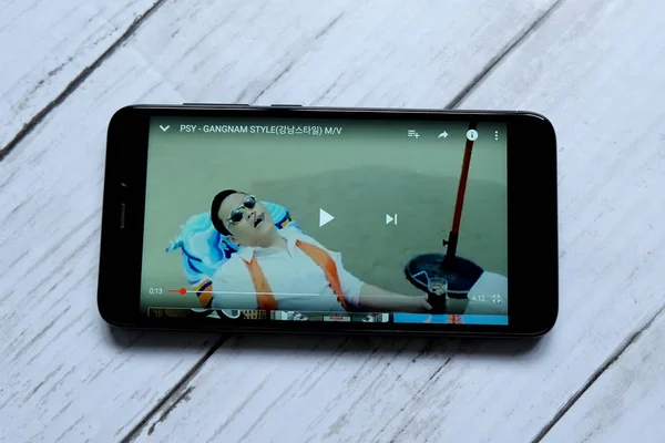 Kuala Lumpur, Malezya - 28 Ocak 2018: Yukarıdan Gangnam tarzı müzik video oynarken smartphone. Gangnam tarzıdır 18 K-pop single'ı Güney Koreli müzisyen Psy.