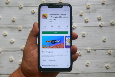KULIM, MALAYSIA - 8 Nisan 2020: Kelime ve Arkadaşlarla Kelime 2 'nin android uygulamaları ile akıllı telefonu tutan bir elin üst görünümü.