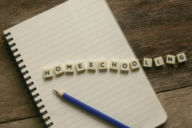 Not defteri, kalem ve kelime kübü alfabesinin en üst görünümü Tahta arka planda evde eğitim.