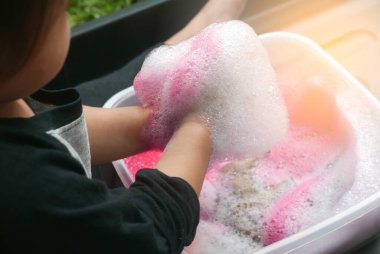 Kırmızı renkli sabun köpüğüyle oynayan çocukların seçici odak noktası.