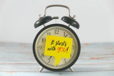 İlham verici alıntılarla yazılmış sarı konuşma balonlu klasik çalar saat Seninle Başlıyor!.