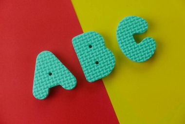 Kırmızı ve sarı olan iki renk arkaplan üzerindeki ABC alfabesinin üst görünümü.