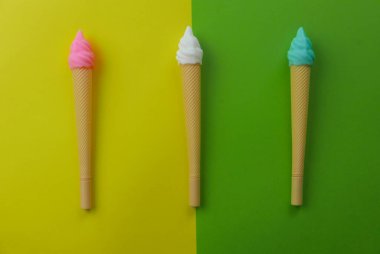 İki renk arkaplan üzerindeki bir dondurma kaleminin üst görünümü yeşil ve sarı.