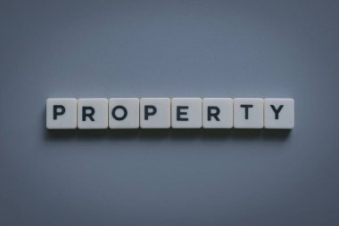 Gri arkaplanda kare harften oluşan özellik sözcüğü.