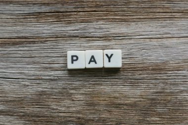 Tahta arka planda kare harften yapılmış ödeme sözcüğü.