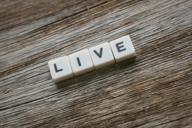 Tahta arka planda kare harften yapılmış canlı kelime.