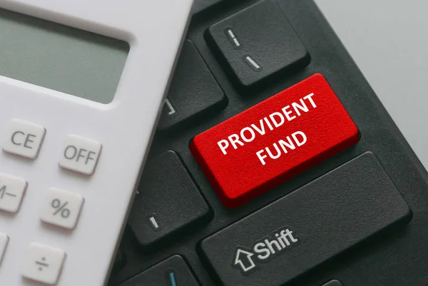 Provident fonu ile yazılmış kırmızı düğmeli hesap makinesi ve klavyenin seçici odağı. İş ve finans kavramı.