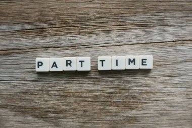 Ahşap arka planda kare harften oluşan yarı zamanlı kelime.