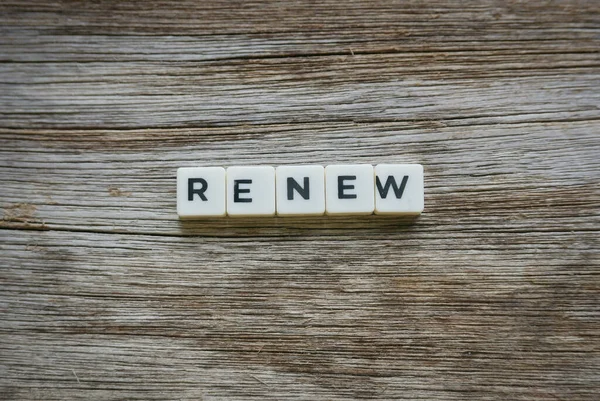 Renew word made of square letter word on wooden background.