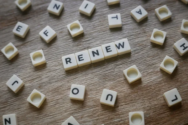 Renew word made of square letter word on wooden background.