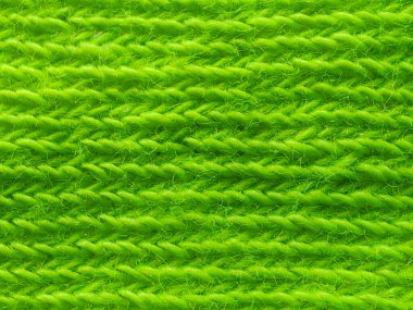 Detaylı yatay kaburga dokusuna sahip canlı, yeşil örülmüş kumaş, yakın çekim makro görüşünde pürüzsüz ve düzenli bir desen gösteriyor..
