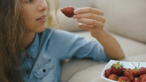 美しい十代の少女イチゴ。美しい十代の少女はイチゴを食べて、笑顔します。ステディカム ショット — ストック動画