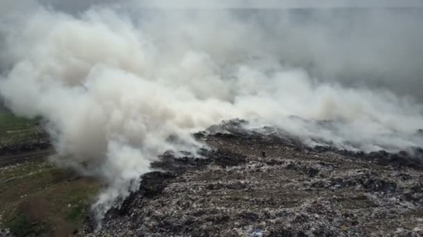 El basurero contamina el medio ambiente. Viento fuerte eleva humo tóxico de basura ardiendo en el aire . — Vídeo de stock