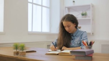 Dizüstü bilgisayar ile genç kız ev ödevi yapıyor. Üniversite eğitimi. Kız öğrenci evde ders çalışıyor.