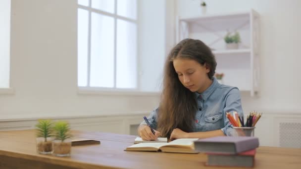 Chica joven con computadora portátil está haciendo la tarea. Educación universitaria. Mujer estudiante está estudiando en casa . — Vídeo de stock