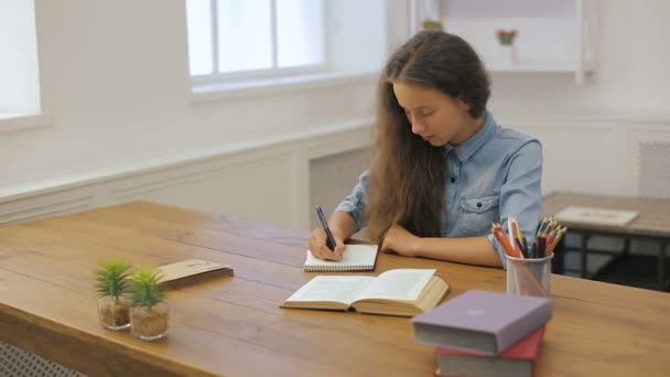 Młoda dziewczyna z komputera przenośnego jest odrabiania lekcji. Nauki w college'u. Kobiet student studiuje w domu. — Wideo stockowe