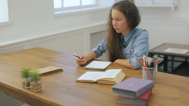 Młoda dziewczyna z komputera przenośnego jest odrabiania lekcji. Nauki w college'u. Kobiet student studiuje w domu. — Wideo stockowe