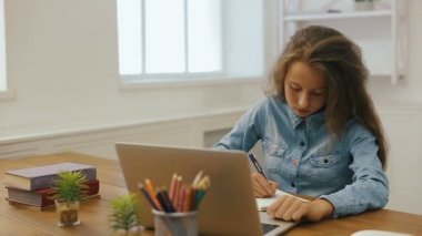 Dizüstü bilgisayar ile genç kız ev ödevi yapıyor. Üniversite eğitimi. Yorgun kız öğrencinin eğitim ve pc evde kullanma.