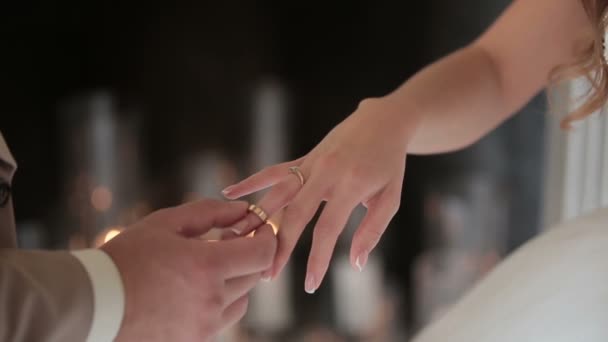 Damat nikah yüzüğü gelinler parmağında koyar. Evlilik yüzükler elleriyle. Gelin ve damat Nikah yüzükleri değişimi. — Stok video