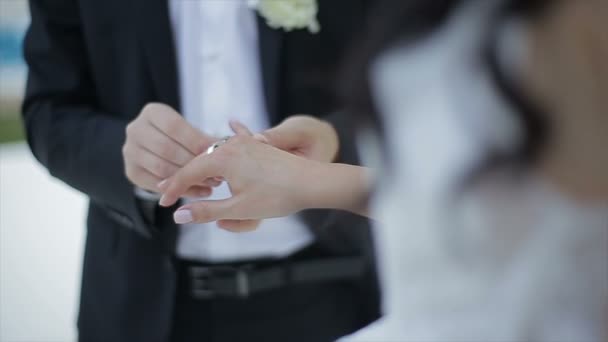 Groom puts the wedding ring on Brides finger. Marriage, hands with rings. The bride and groom exchange wedding rings. — Stock Video