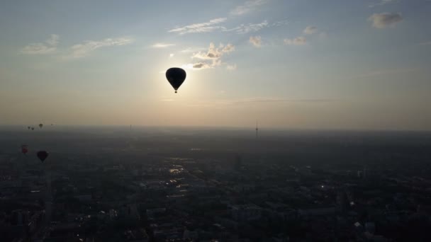 Пташиного польоту повітряних кулях через місто Вільнюс, Литва. Повітряних кулях ширяє над місто на світанку. — стокове відео