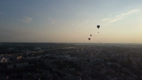 Vista aérea de balões de ar quente sobre a cidade de Vilnius, Lituânia. Balões de ar quente flutuando sobre a cidade ao amanhecer . — Vídeo de Stock