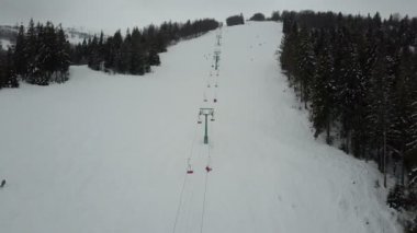 Teleferik Karpat Dağları'nda üzerinde uçuş. Kayaklar üzerinde azalan insan havadan görünümü.