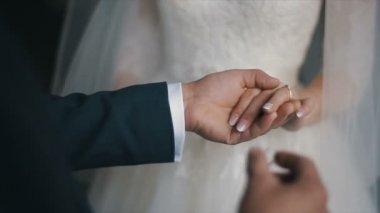 Damat gelini parmağında alyans koyar. Evlilik yüzükler elleriyle. Gelin ve damat nikah yüzükleri değişimi.