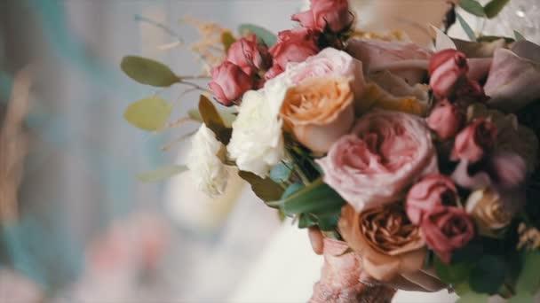 Noiva está segurando belo buquê de casamento de flores diferentes. Buquê de noiva no dia do casamento. Buquê de belas flores rosa, creme e branco — Vídeo de Stock