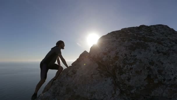 Альпинист достигает вершины. Человек поднимается на гору и празднует успешное восхождение. — стоковое видео